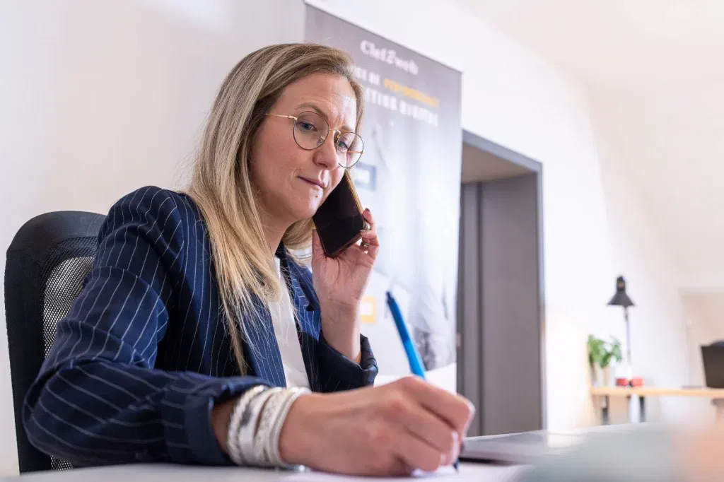 Experte de notre agence SEA (Elise Honorez) en contact au téléphone avec l'un de ses clients